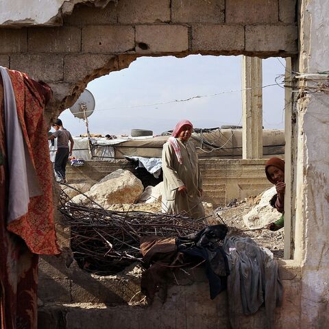 Displaced Syrians walk through a makeshift camp for Syrian refugees only miles from the border with Syria in the Bekaa Valley on Nov. 12, 2013, in Majdal Anjar, Lebanon. 